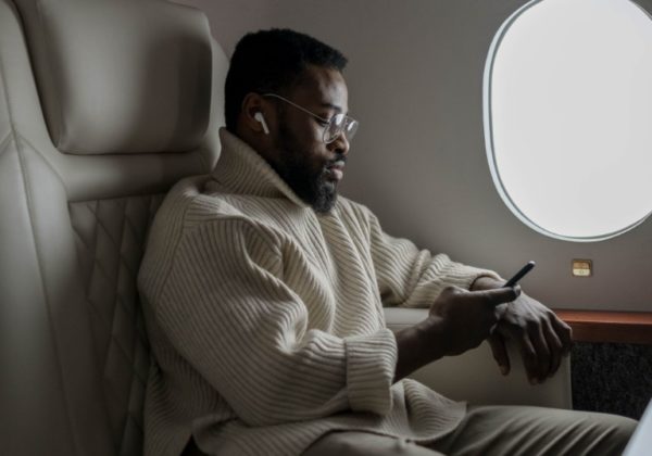 Wealthy-male-sitting-on-plane-with-phone